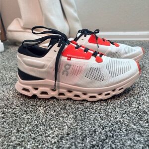 On CloudStratus Orange, White, and Black Athletic Shoes